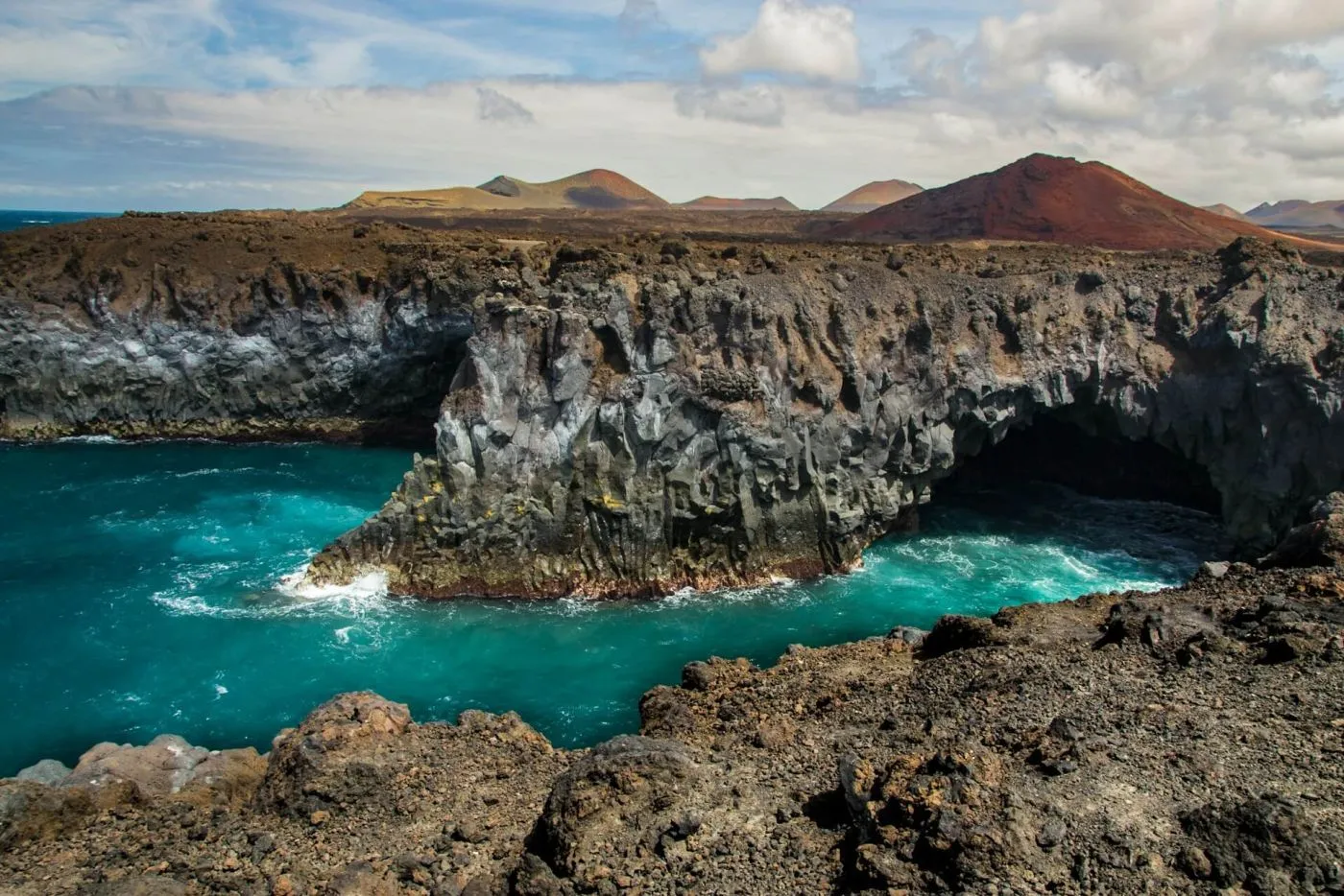 Los Hervideros cliffs with waves crashing into lava tubes